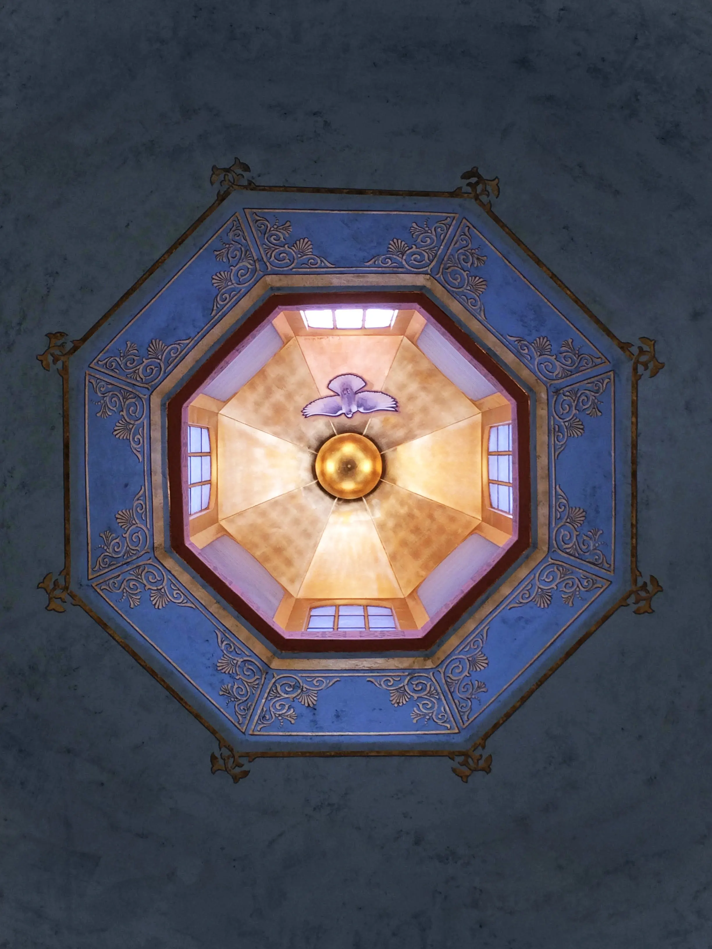 Painted octagonal dome with a gilded central boss, stencilled blue border and a dove of the Holy Spirit