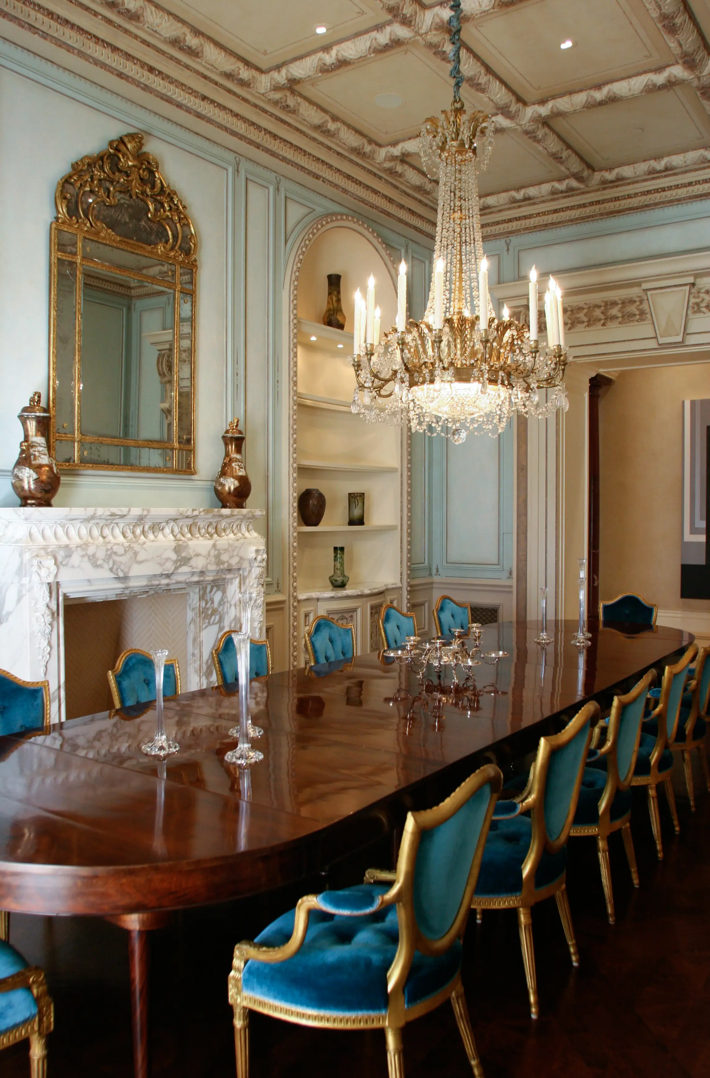 Formal dining room with glazed panelling, carved marble chimneypiece and gilded ornament