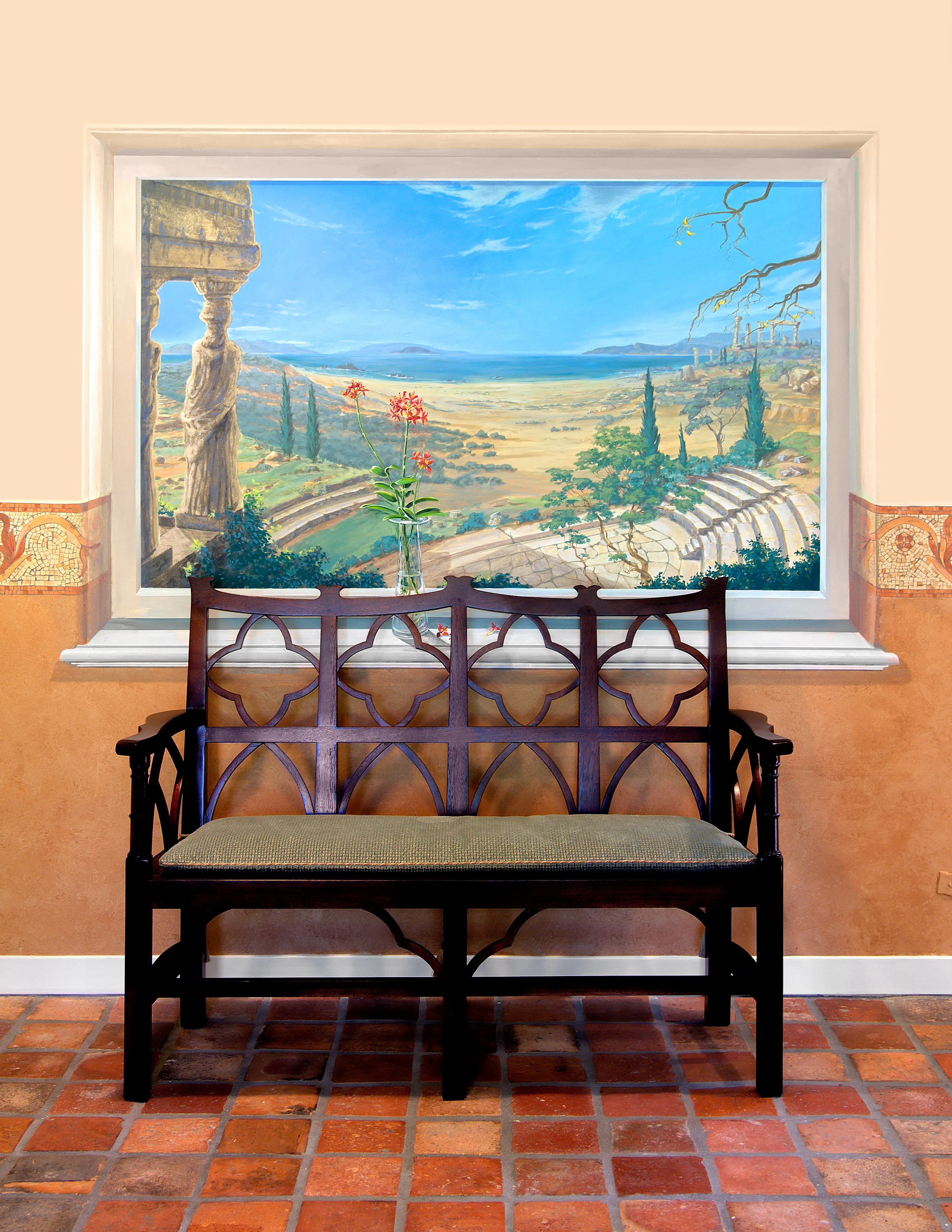 Burnished terracotta lime plaster walls with painted mosaic banding behind a carved bench
